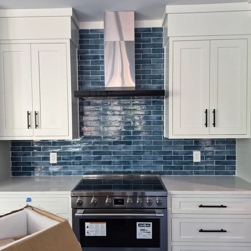 Blue glass subway backsplash behind a kitchen range