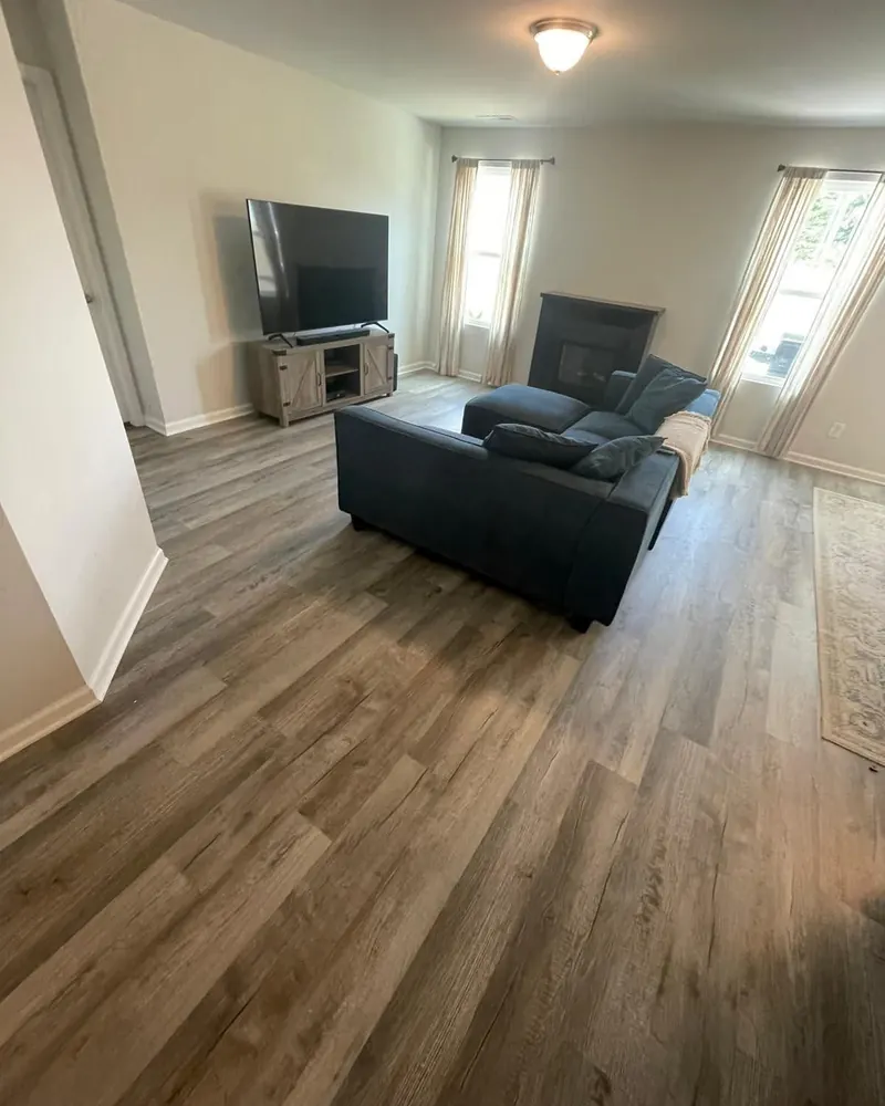 Wood-look porcelain plank replacing carpet in an open living area