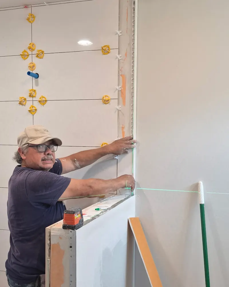 Setting wall tile to a laser line with levelling clips
