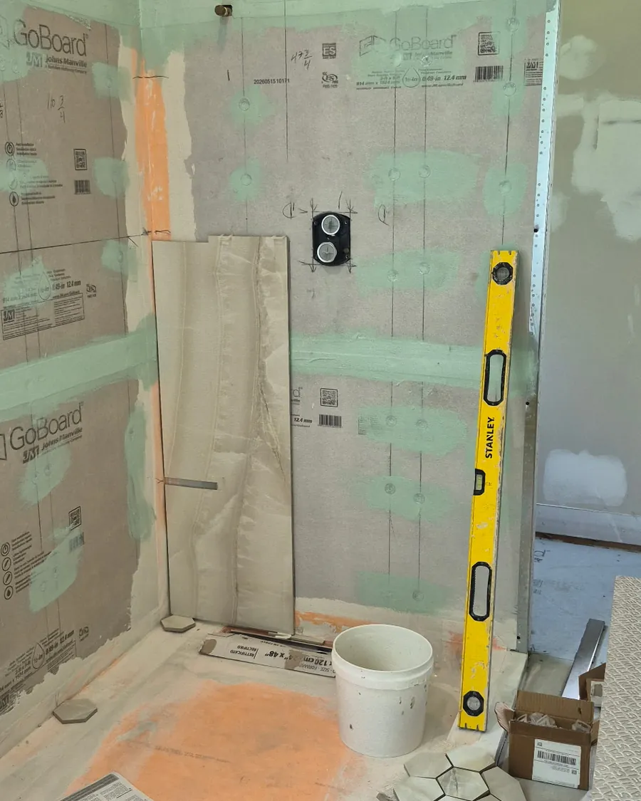 Waterproof backer board with taped seams, checked for plumb with a spirit level